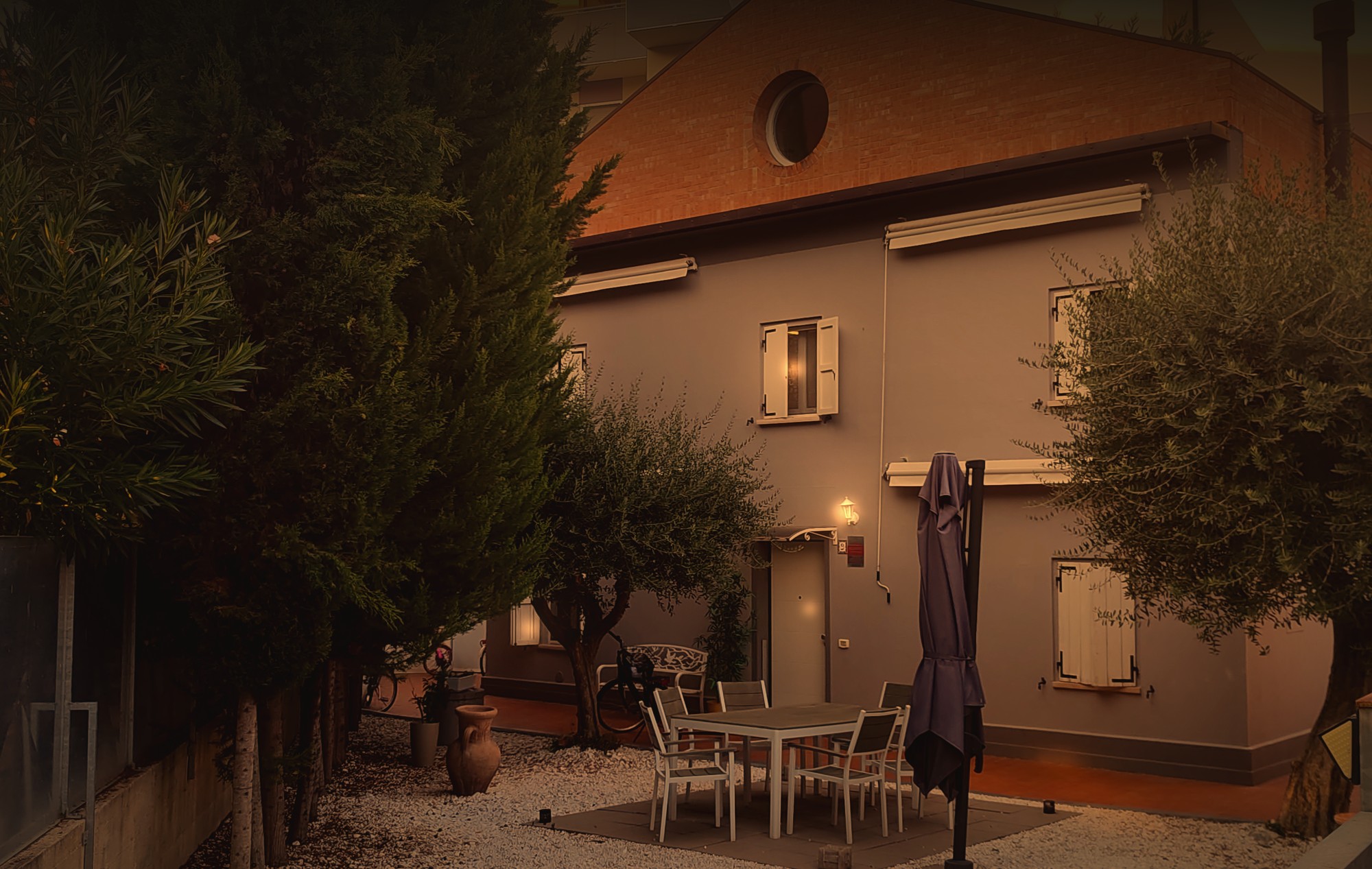 La villetta vista dal giardino, con il tavolo sotto gli ulivi